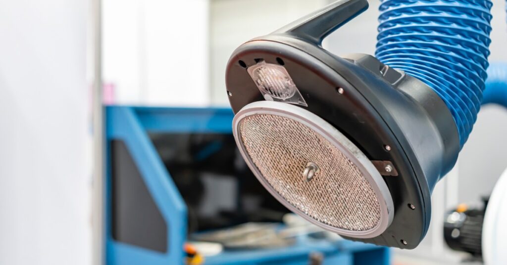 Close-up of the front of a tube on a welding fume extractor. It features a blue tube and a filter on the system's head.